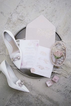 Wedding invitation on silver tray with Bride's white shoes and ring boxes