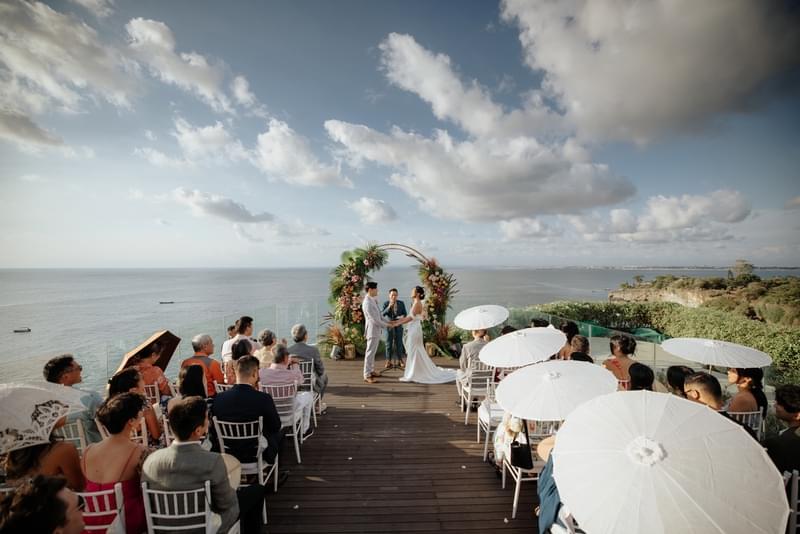 Outdoor wedding ceremony at Ayana Villa's clifftop deck, featuring a floral arch and panoramic ocean views