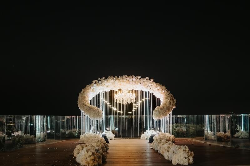 Elegant wedding altar featuring cascading floral arrangements and a crystal chandelier, creating a stunning centerpiece for a night ceremony at Ayana Villa