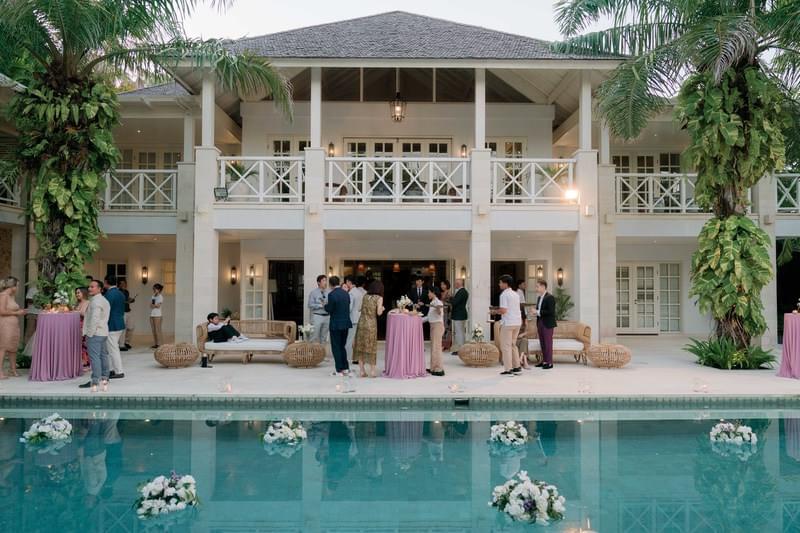  Guests mingling by the poolside during an elegant wedding reception in illa Tamarama at The Ungasan 