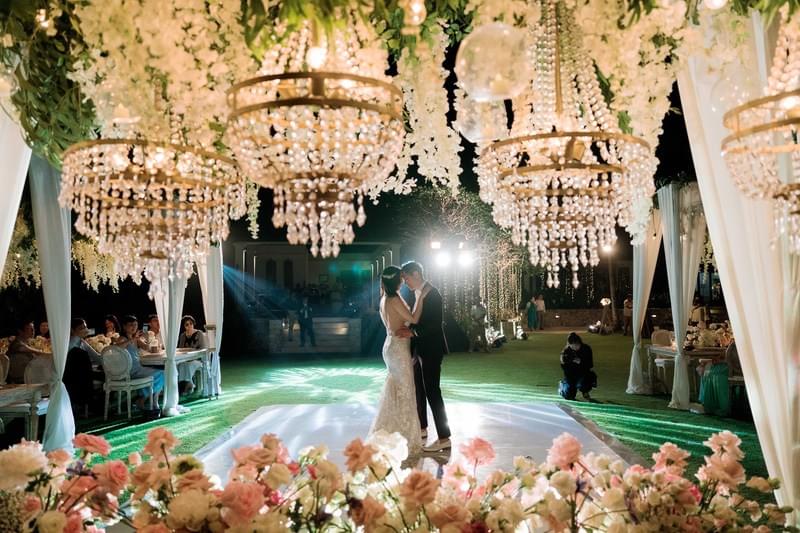  Bride and groom sharing their first dance under cascading floral chandeliers on a romantic evening at The Ungasan 