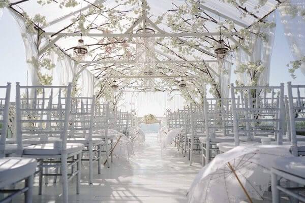Elegant wedding ceremony setup at Ayana's Sky Platform with a white floral canopy, delicate hanging decorations, and ocean views under a bright sky.