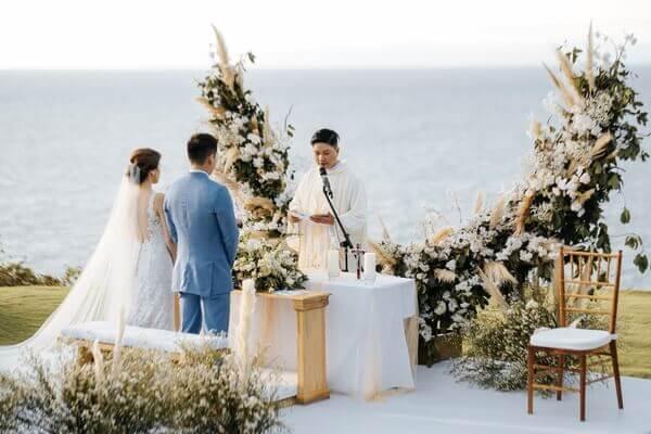 * Charming wedding ceremony setup at Ayana Sky amphitheatre with bride and groom and celebrant with a stunning ocean and mountain view backdrop. 