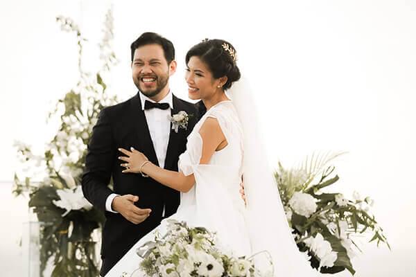 Bride and Groom embracing surround by white flowers